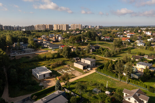 Drone photography of suburban houses and multistory apartment blocks in the background