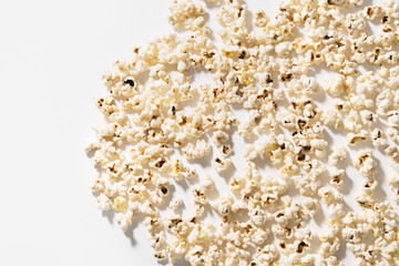 Scattered popcorn on white background with hard lighting