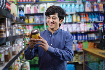 Happy man purchasing in a grocery store. Buying grocery for home in a supermarket. examining a product