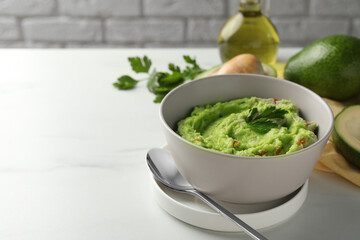 Delicious guacamole served on white table, space for text