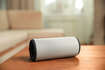Portable bluetooth speaker on wooden table indoors. Audio equipment