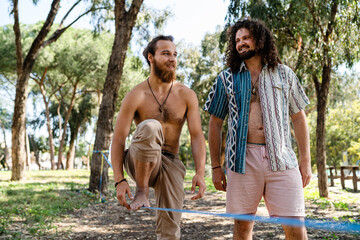 Two men slacklining in city park during summer day