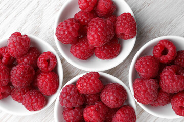 Tasty ripe raspberries on white wooden table, flat lay