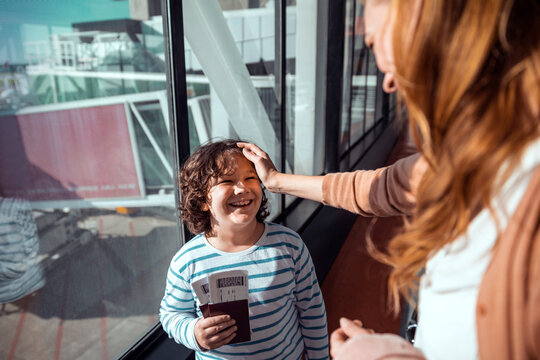 Young mother and son waiting for their flight at the airport
