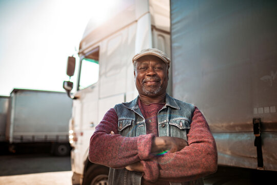Portrait of a confident African American truck driver in front of his vehicle
