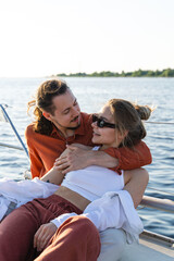 Fototapeta na wymiar Young attractive couple relaxing on the sailboat during sailing in the sea