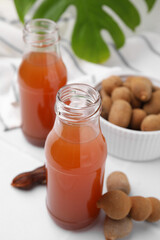Tamarind juice and fresh fruits on white table, closeup