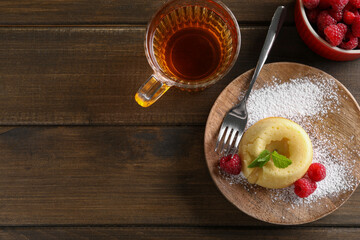 Tasty vanilla fondant with white chocolate and raspberries served on wooden table, flat lay. Space for text