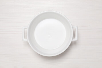 Empty pot on white wooden table, top view