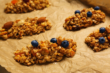 Fototapeta premium Different granola bars on parchment paper, closeup. Healthy snack