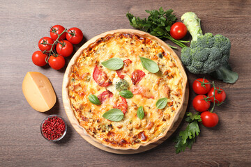 Tasty cheese quiche and ingredients on wooden table, flat lay