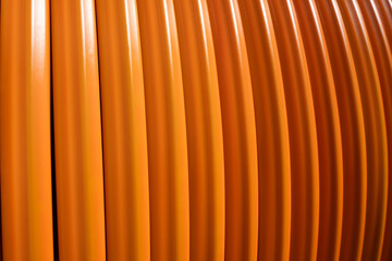 Rolled up orange colored fiber optic cable for laying in underground