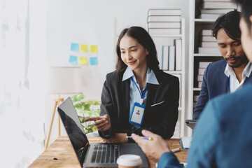 Obraz premium Group of young Asian business people talk, consult, discuss working with new startup project idea presentation analyze plan marketing and investment.