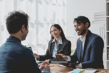 Group of young Asian business people talk, consult, discuss working with new startup project idea presentation analyze plan marketing and investment.