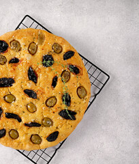 Italian focaccia with olives and dried plums , on a light background, copy space