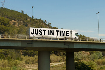 A truck is driving across the bridge, with the inscription on the trailer - just in time.