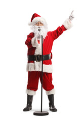 Santa claus with a microphone singing and pointing with finger
