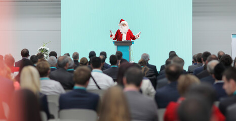 Santa claus speaking on a pedestal in front of audience