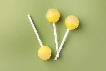Tasty lollipops on green background, flat lay