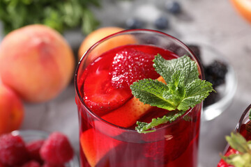 Glass of delicious refreshing sangria on blurred background, closeup view