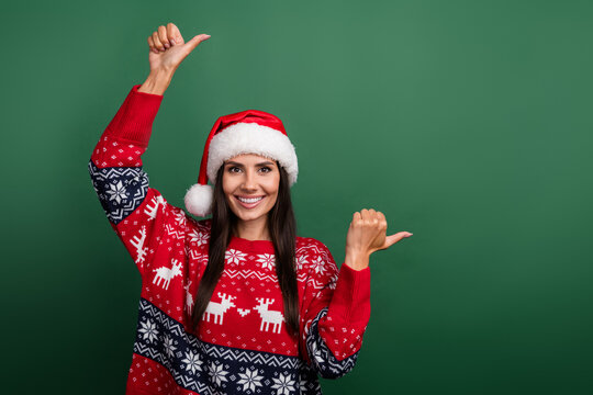 Photo of sweet cute woman santa elf wear ornament x-mas pullover pointing two thumbs empty space isolated green color background