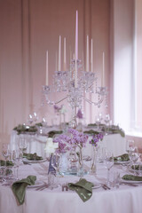 Elegant table setting with candelabra and purple flowers. High quality photo