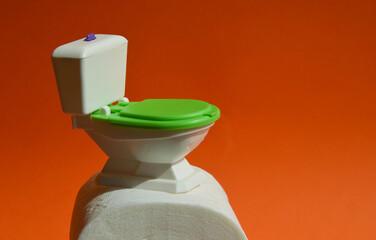 a small toilet and toilet paper. hygiene supplies. background for the design