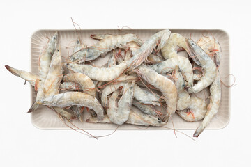 A dish with frozen shrimp isolated on a white background. Fresh shrimps are laid out on the table. Products for grilling. Frozen shrimp.