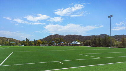 Empty soccer field with blue sky in public park