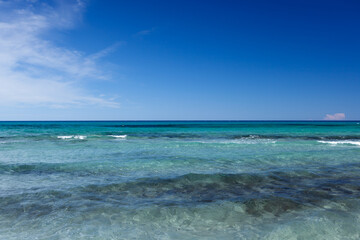 Amazingly beautiful clear blue turquoise water of the Mediterranean sea with blue sky at Sardinia, Italy on a sunny day.