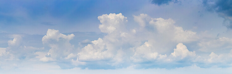 White curly clouds in the blue sky in sunny weather