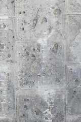 Texture of a gray concrete wall with traces of dismantled facing tiles