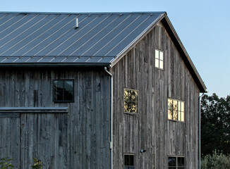 Fototapeta na wymiar old wooden barn detail at sunset (glare in the windows) rural building, house, wood