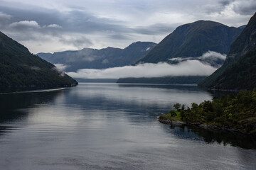 Fototapeta na wymiar Spectacular Geiranger Fjord with low clouds between mountains, Norway