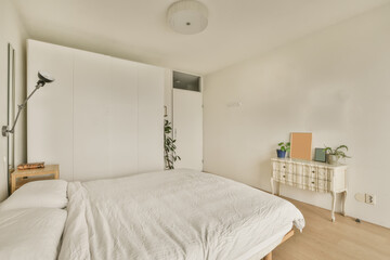 a bedroom with a bed, dresser and cabinetd cupboards in the same color as they appear on the wall