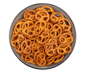 Salted pretzels pile, party snacks in bowl isolated on white, top view
