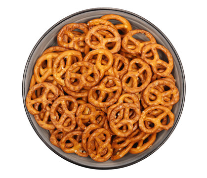 Salted pretzels pile, party snacks in bowl isolated on white, top view
