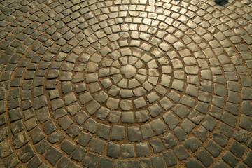 The pavement is paved with stones in the shape of a circle.