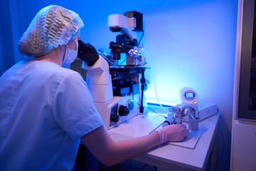 Experienced female scientist performing ICSI procedure in laboratory setting