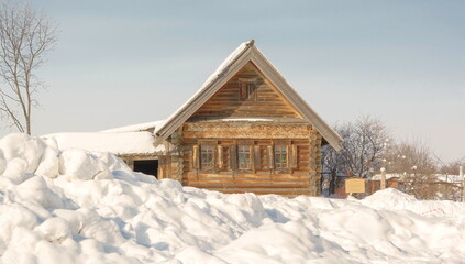 Log hut on a snow-covered village street