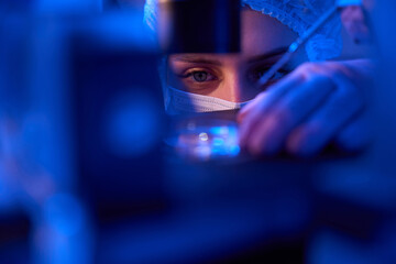 Experienced female scientist preparing specimens for microscopic examination