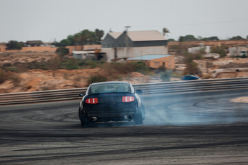 Sport car go fast at the corner with a clouds of smoke. Car make a drift at the racetrack