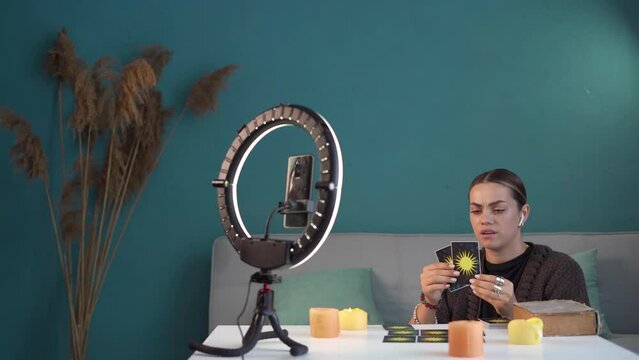 Female video blogger telling her audience about oracle cards sitting at home