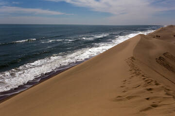 Red sand dunes meet the ocean