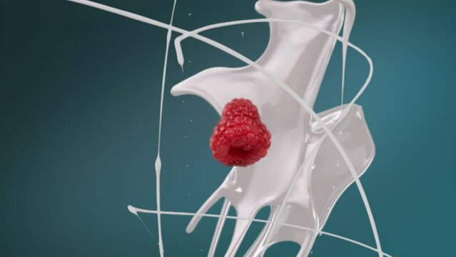Fresh milk splash falling in slow motion with droplets and raspberry