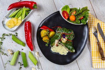 Spinach fish wrap. Spinach wrap served with salad and baked potatoes, fresh vegetables and fruit on the side. Pescetarian food