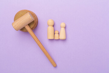 Wooden family figures with judge's gavel on color background,top view