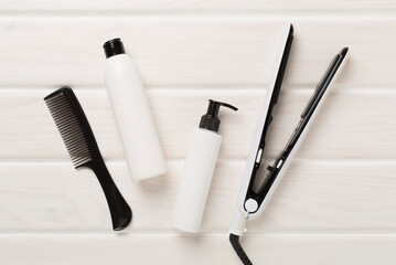 Hair straightener with thermo protection on wooden background, top, view