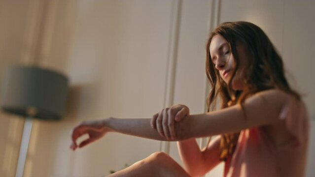 Gorgeous woman moisturising skin closeup. Calm girl massaging hands using lotion