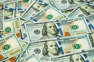 many hundred dollar bills on the table. the concept of successful enrichment